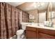 Cozy bathroom featuring a vanity with a wooden cabinet, a decorative shower curtain, and neutral wall color at 6853 S Russet Sky Way, Gold Canyon, AZ 85118