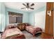 Comfortable bedroom with twin beds, window, ceiling fan, and light blue walls at 6853 S Russet Sky Way, Gold Canyon, AZ 85118