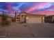 Charming single-story home with a two-car garage, low maintenance desert landscaping, and a stunning sunset at 6853 S Russet Sky Way, Gold Canyon, AZ 85118