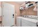 Well-organized laundry room with full-sized washer and dryer, shelving, and a door to the garage at 6853 S Russet Sky Way, Gold Canyon, AZ 85118
