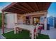 Inviting covered patio with a wooden pergola, an outdoor dining set, and a view of the lush backyard at 6853 S Russet Sky Way, Gold Canyon, AZ 85118