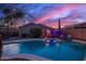 Gorgeous backyard pool and spa with lush landscaping and a covered outdoor dining area under a twilight sky at 6853 S Russet Sky Way, Gold Canyon, AZ 85118