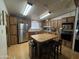 Functional kitchen with wood cabinets, stainless steel appliances, and an island with seating at 6960 W Peoria Ave # 212, Peoria, AZ 85345