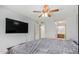Spacious bedroom with a ceiling fan and large bed, featuring a wall-mounted TV at 700 E Mesquite Cir # N125, Tempe, AZ 85288