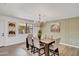 Dining area featuring a rectangular dark wood table, six upholstered chairs, and a modern chandelier above at 736 N Meadows Dr, Chandler, AZ 85224
