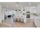 Open kitchen flows into a living area with an island, seating, stainless steel appliances and bright lighting at 736 N Meadows Dr, Chandler, AZ 85224
