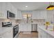 Bright modern kitchen with white cabinets, stainless steel appliances, white quartz countertops and backsplash at 736 N Meadows Dr, Chandler, AZ 85224