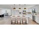 Bright kitchen with white cabinets, stainless steel appliances, large island and stylish pendant lighting at 736 N Meadows Dr, Chandler, AZ 85224