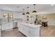 Bright kitchen with white cabinets, stainless steel appliances, large island and stylish pendant lighting at 736 N Meadows Dr, Chandler, AZ 85224