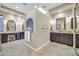 Luxurious bathroom features dual vanities, elegant mirrors, and a central partition accented with decorative tiles and soft lighting at 7500 E Pontebella Dr, Scottsdale, AZ 85266