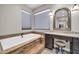 The primary bath showcases a soaking tub with tile surround, a vanity area, and natural light from dual windows at 7500 E Pontebella Dr, Scottsdale, AZ 85266