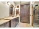This bathroom boasts a granite countertop, dark wood cabinetry, and a shower with decorative stone accents, offering a serene escape at 7500 E Pontebella Dr, Scottsdale, AZ 85266