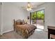 Comfortable bedroom with a patterned bedspread, ceiling fan, and a sliding door to the outdoor patio at 7500 E Pontebella Dr, Scottsdale, AZ 85266