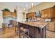 Spacious kitchen island with granite countertops, wooden cabinetry, and bar stool seating at 7500 E Pontebella Dr, Scottsdale, AZ 85266