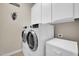 Functional laundry room with a stacked washer and dryer, plus overhead cabinet storage at 7500 E Pontebella Dr, Scottsdale, AZ 85266