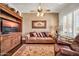 Comfortable living room showcasing a plush sofa, built-in shelves, and a decorative ceiling fan at 7500 E Pontebella Dr, Scottsdale, AZ 85266