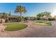 Spacious backyard featuring lush landscaping, a putting green, mature trees, and serene desert landscaping at 8220 W Mariposa Grande Ln, Peoria, AZ 85383