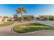 Lush backyard with desert landscaping, mature trees, putting green, and a circular area with decorative rock at 8220 W Mariposa Grande Ln, Peoria, AZ 85383