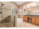 Bathroom featuring a glass-enclosed shower, soaking tub, and dual vanities with wood cabinets at 8220 W Mariposa Grande Ln, Peoria, AZ 85383