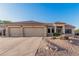 Charming home featuring a spacious three-car garage, tile roof, and desert landscaping at 8220 W Mariposa Grande Ln, Peoria, AZ 85383