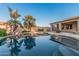 Sparkling swimming pool with rock accents and mature palm trees offers a refreshing outdoor escape at 8220 W Mariposa Grande Ln, Peoria, AZ 85383