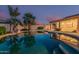 Inviting backyard pool with stone features and lush tropical landscaping creates a private outdoor oasis at 8220 W Mariposa Grande Ln, Peoria, AZ 85383