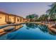 Backyard pool area with island, tropical landscaping and lighting at 8220 W Mariposa Grande Ln, Peoria, AZ 85383