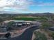 Aerial view of a golf course, golf cart parking, and clubhouse surrounded by desert landscape at 9747 S 182Nd Dr, Goodyear, AZ 85338