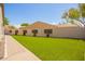 Spacious backyard with artificial grass, decorative planters, and block wall fencing for enhanced privacy at 9747 S 182Nd Dr, Goodyear, AZ 85338