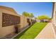 View of the backyard with artificial grass and decorative wall panels, a low-maintenance design at 9747 S 182Nd Dr, Goodyear, AZ 85338