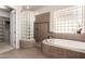 The bathroom offers a luxurious soaking tub, separate shower and large glass block window at 9747 S 182Nd Dr, Goodyear, AZ 85338