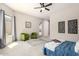 The bedroom features two green chairs, neutral carpet, ceiling fan, and a large window with curtains at 9747 S 182Nd Dr, Goodyear, AZ 85338