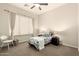 This bedroom features a bed, a window with curtains, carpeted floor, a chair and two nightstands at 9747 S 182Nd Dr, Goodyear, AZ 85338