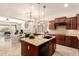 Open kitchen with cherry cabinets, granite countertops, and island seating is an entertainer's dream at 9747 S 182Nd Dr, Goodyear, AZ 85338