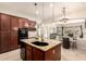 Gourmet kitchen features granite island with a sink and view to the living room at 9747 S 182Nd Dr, Goodyear, AZ 85338