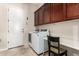 Well-equipped laundry room with modern washer and dryer, sleek countertops, and ample storage at 9747 S 182Nd Dr, Goodyear, AZ 85338