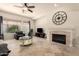 Inviting living room with a fireplace, travertine floors, a ceiling fan, and an abundance of natural light at 9747 S 182Nd Dr, Goodyear, AZ 85338