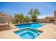 Beautiful backyard pool with a spa, lush landscaping, and desert views for relaxation at 9747 S 182Nd Dr, Goodyear, AZ 85338