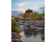 Scenic water feature with cascading waterfall and unique architectural tower, set against a colorful sunset sky at 9747 S 182Nd Dr, Goodyear, AZ 85338
