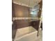 Bathroom featuring a tub with a glass partition and dark colored tiling at 11035 N 37Th St, Phoenix, AZ 85028