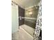 Bathroom featuring a tub with glass partition and decorative gray and white mosaic tile accents at 11035 N 37Th St, Phoenix, AZ 85028