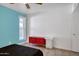 Bedroom featuring light blue accent wall, wood-look tile floors, and a red cabinet at 11035 N 37Th St, Phoenix, AZ 85028