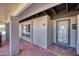 Covered front porch with decorative front door, brick floor and beam accents at 11035 N 37Th St, Phoenix, AZ 85028