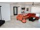 Bright living room with neutral tile flooring, orange leather furniture, and a modern ceiling fan at 11035 N 37Th St, Phoenix, AZ 85028