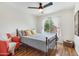 Cozy bedroom featuring a bed, chair, ceiling fan, and a large window with natural light at 1138 E Liberty Shores Dr, Gilbert, AZ 85234