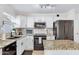 Modern kitchen with granite countertops, white cabinets, black appliances, and subway tile backsplash at 1138 E Liberty Shores Dr, Gilbert, AZ 85234