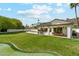 Backyard featuring a putting green, lush green lawn, and views of the pool and covered patio at 14401 N Coral Gables Dr, Phoenix, AZ 85023