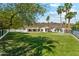 Expansive backyard with lush green lawn, mature trees, putting green, and covered patio at 14401 N Coral Gables Dr, Phoenix, AZ 85023