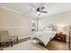 Cozy bedroom featuring hardwood floors, crown molding, and a ceiling fan at 14401 N Coral Gables Dr, Phoenix, AZ 85023