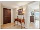 Welcoming foyer with a decorative wood front door, tiled floor, and an antique table at 14401 N Coral Gables Dr, Phoenix, AZ 85023